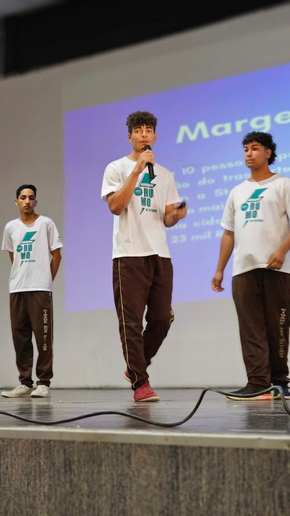 Estudantes apresentando o pitch de seus projetos no palco