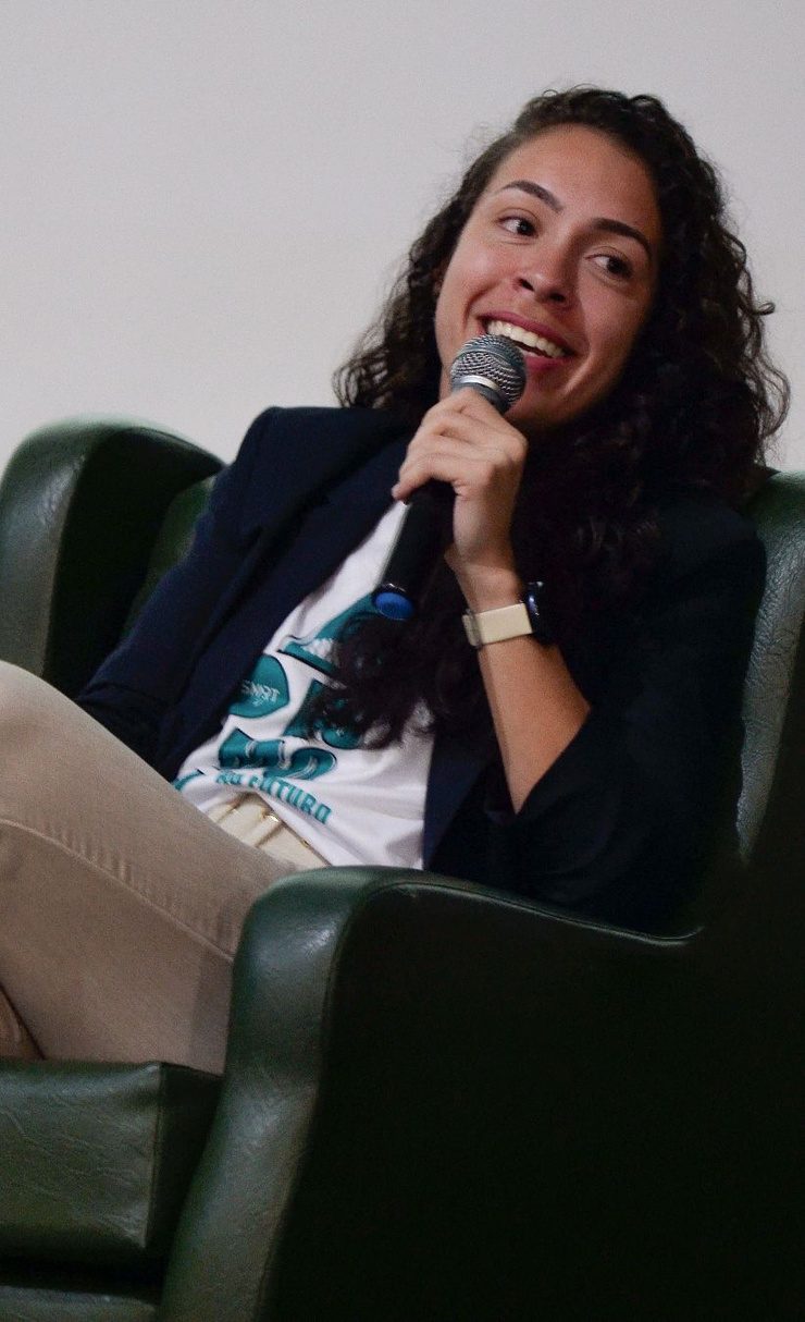 Karina Romano falando ao microfone durante um evento